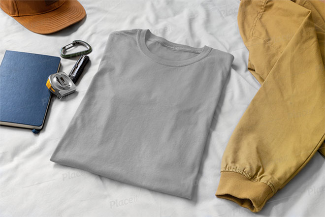 Mockup of a Folded T-Shirt on a Bed